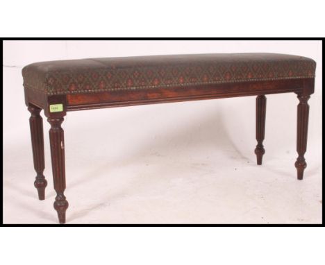 A Victorian style mahogany duet piano window stool seat with overstuffed seat being raised on tapering legs. Measures H36 x W