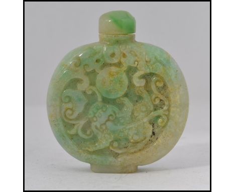 A Chinese green jade perfume bottle / moon flask with carved relief designs to the sides complete with the stopper