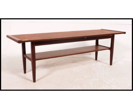A vintage / retro 1970's surfboard style teak coffee table raised on turned legs with magazine rack to the underside H36xW104