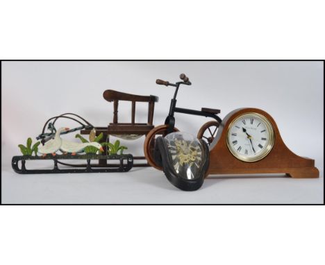 A mixed lot to include wooden dolls tricycle and slay along with a cast iron coat pegs in the form of ducks and a mantel cloc