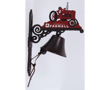 A cast iron exterior hanging door bell on a bracket, the top decorated with a Farmall tractor. Hand painted, with bell beneat