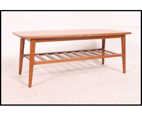 A vintage / retro 1970's Danish Influence solid teak coffee table raised on turned legs with magazine rack to the underside H