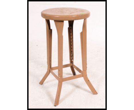 A retro vintage mid 20th century painted industrial metal adjustable  machinists chair, having a circular seat pad raised on 