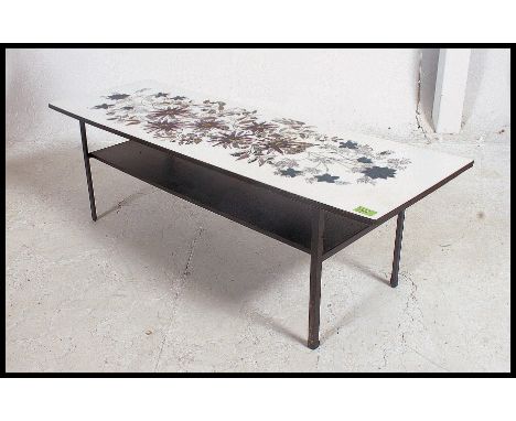 A vintage 1970's retro melamine long John coffee table raised on ebonised plinth base