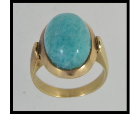 An Art Deco tested 14ct gold and turquoise set ladies dress ring. The cabochon turquoise set over plain shank. Weight 6.4g / 