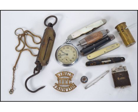 A mixed lot to include a collection of 5x assorted vintage penknives, scales, cap badges etc