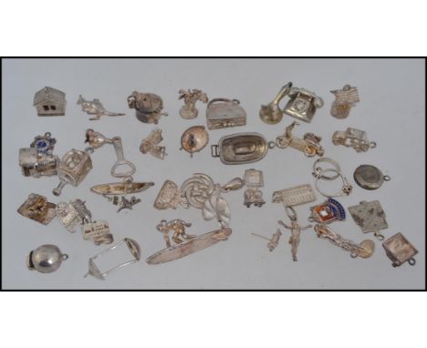 An extensive collection of white metal and silver white metal charms from a large charm bracelet. To include telephone, wishi