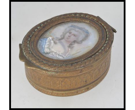 A 19th century Georgian brass oval pill box with lined interior having inset ivory / bone portrait painting study of a maiden