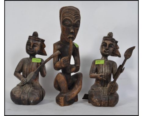 3 Vintage wooden figures of Polynesian origin.  Two playing stringed instruments with the other larger figure smoking or play