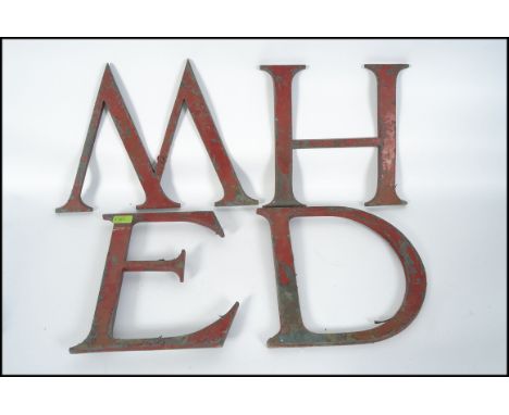 A collection of vintage early 20th century Industrial advertising metal letters to include letters M, H, E, D.