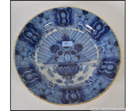 An 18th / 19th century Delft blue and white plate decorated with a spray of peacock feathers in a fan design bearing arrow un
