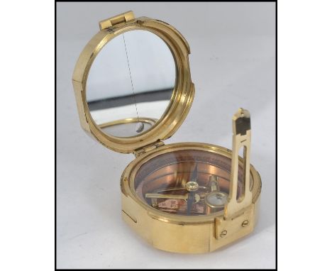 A brass cased compass and sundial set in a circular brass case with hinged cover, notation to outer