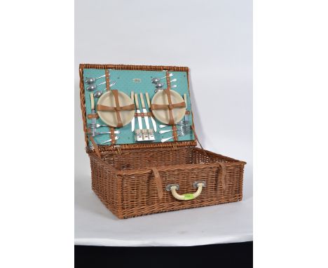 A Sirram vintage mid century picnic hamper complete with some contents in a good original whicker hamper with leather straps.