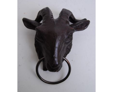 A cast iron wall hanging animal stay / lead tie in the form of a goats head. With large hoop to front.