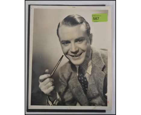 JOHN MILLS; A rare early 8x10" black and white photograph of a very young Sir John Mills. Seated smiling, with pipe to hand. 
