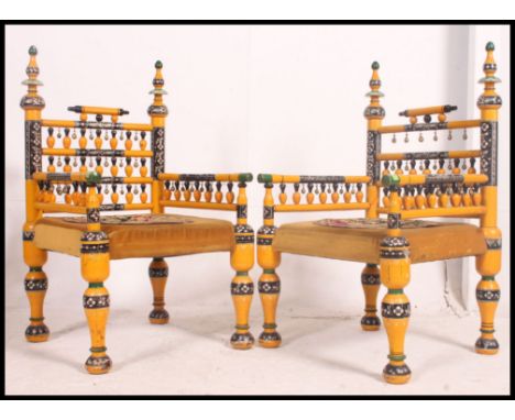 A stunning pair of Indian handpainted yellow opium / hall chairs raised on turned legs with overstuffed velour needlepoint se