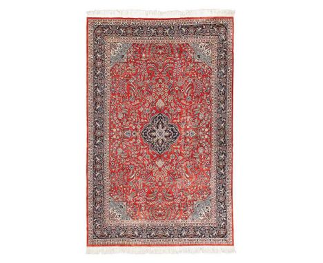 PERSIAN STYLE CARPET LATE 20TH CENTURY the rust red field with indigo medallion, light blue and ivory spandrels, within indig