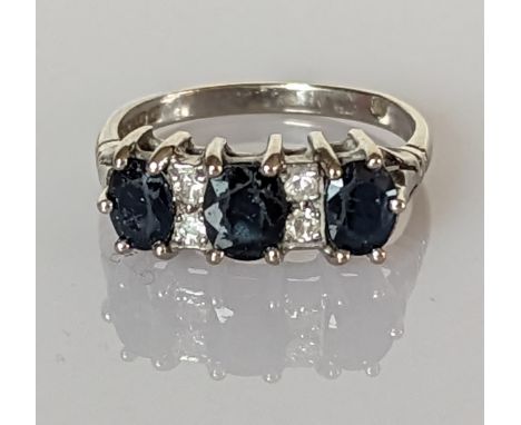 A three-stone graduated sapphire and diamond ring on a white gold setting, largest sapphire 6 x 5mm, size O, hallmarked 18ct,