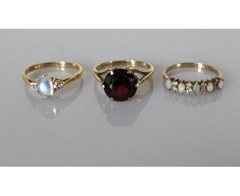 A moonstone and diamond ring on an 18ct yellow gold setting, 2.15g; a faceted garnet dress ring in a gold, claw setting and a