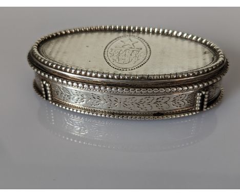 A George III oval silver snuff box with hinged lid, beaded border, engine turned, etched decoration with gilt interior, initi