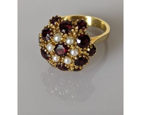 An Edwardian ruby and pearl cluster dress ring on a yellow gold setting, stamped 750, size O, 8.4g