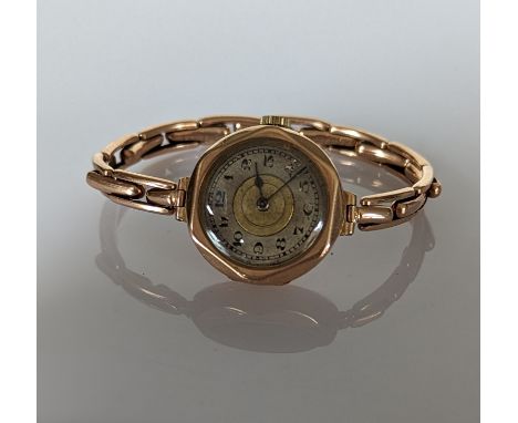 A 1920s ladies manual wristwatch with Arabic numerals, hexagonal rose gold case and elastic strap, stamped 9ct, 21g, in worki