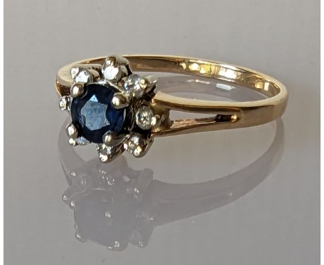 A sapphire and diamond cluster ring on a yellow gold setting, stamped 14k, size R, 2.7g