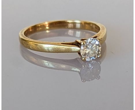 A solitaire diamond ring on a yellow gold claw setting, the round brilliant cut diamond approximately 0.40 carats, hallmarked