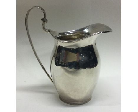 A Georgian style silver cream jug with loop handle. London. Approx. 76 grams. Est. £100 - £150.