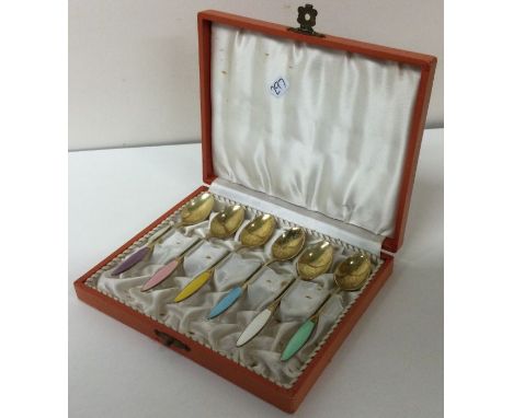 A cased set of six Danish silver gilt and enamel spoons. Approx. 61 grams. Est. £100 - £150.