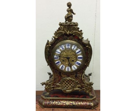 A good French boulle mantle clock attractively decorated with scrolls and figures with brass dial on matching stand. Est. £15