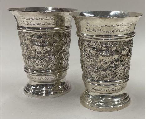 A pair of chased Jubilee silver beakers. Birmingham 1976. By DS Ltd. Approx. 271 grams. Est. £250 - £300