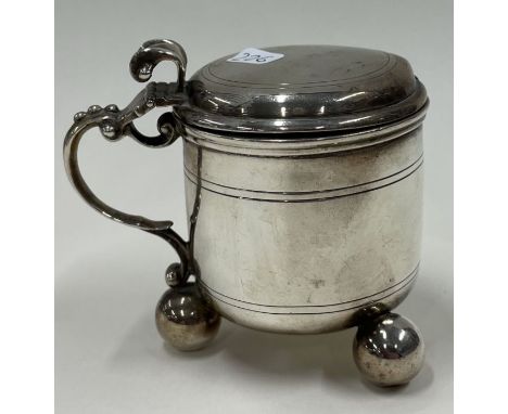 A Victorian silver and glass mustard pot on feet. London 1874. By Goldsmiths Alliance. Approx. 138 grams. Est. £120 - £150.