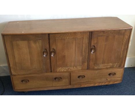 ERCOL: A good three door sideboard. Est. £100 - £150.