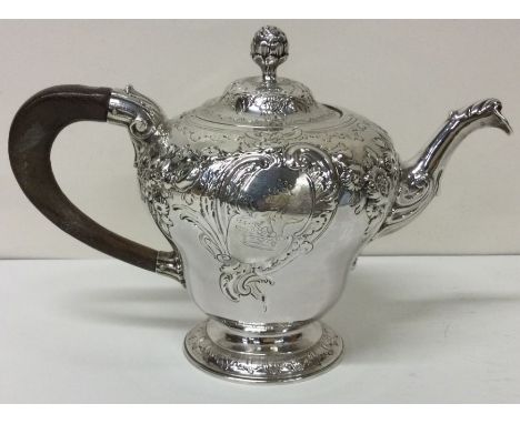 An early George II silver crested chased teapot. London 1748. By John Swift.  Approx. 605 grams. Est. £2000 - £2500.