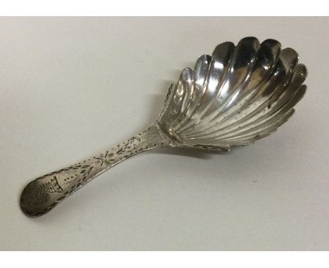 A crested silver caddy spoon with bright-cut handle and fluted bowl. London 1786. By RC. Approx. 10 grams. Est. £50 - £80.