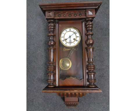 An antique mahogany cased 8 day wall clock with brass and enamel dial.