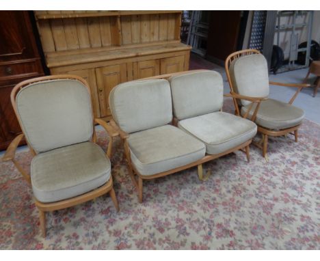 A three piece Ercol elm and beech lounge suite comprising of two seater settee and two armchairs with cushions.