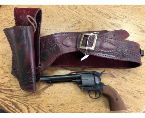 A blank firing replica 1873 Colt 45 Single Action Army chambered in .380 crimped, with a leather gun belt, with a quantity of