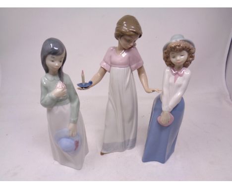 A Nao figure- Girl with candle, together with two further Nao figures.