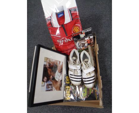 A box containing sporting memorabilia including a pair of boots signed by Stewart Broad, a 1998/99 Manchester United shirt, a