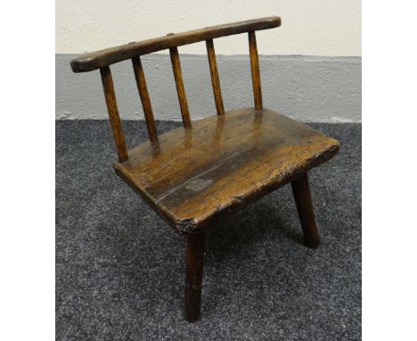 CHILD'S STICK BACK CHAIR in elm, circa 1800, on three feet and with shaped rail and five supporting sticks