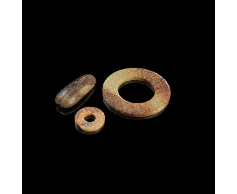 THREE ARCHAISTIC JADE CARVINGScomprising: two bi discs, each finished identically on both sides with raised comma-spirals in 