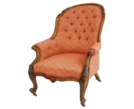 A Victorian walnut armchair, with button back and overstuffed pink upholstery, raised on leaf carved cabriole legs, on cerami