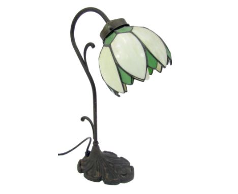 A Tiffany style table lamp, with a petallated milk glass and green shade, on shaped stem and on a rose cast shaped base, 39cm