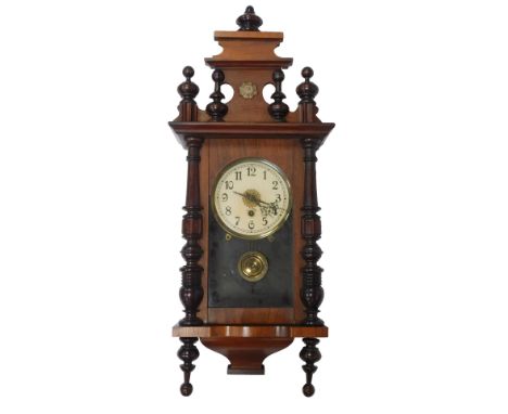 A Vienna walnut cased wall clock, the cream circular enamel dial bearing Arabic numerals, thirty hour, with key and pendulum,