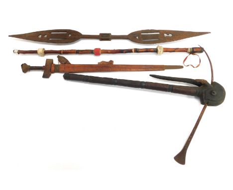A West African wooden and steel ceremonial tribal axe, 70cm high, together with a decorative paddle, sword and leather cane. 