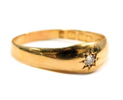An 18ct gold diamond solitaire ring, the star illusion set tiny diamond on a plain band, size R, 3.2g all in.