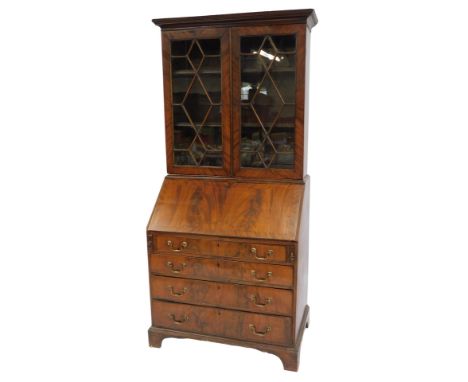 A 19thC mahogany bureau bookcase, the out swept pediment over a pair of astragal glazed doors enclosing two shelves, above a 
