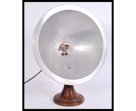 A vintage retro 20th century industrial aluminium heat lamp converted to a table lamp having a large conical shade raised on 